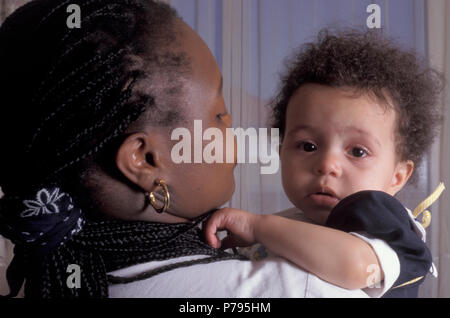Black Mother holding her malheureux mixed race baby girl Banque D'Images