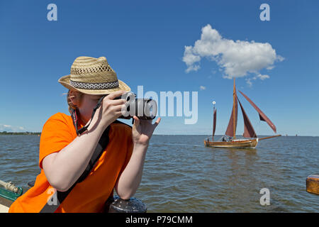 Jeune garçon en prenant des photos des régates Zeesboot, Wustrow, Fischland, Schleswig-Holstein, Allemagne Banque D'Images