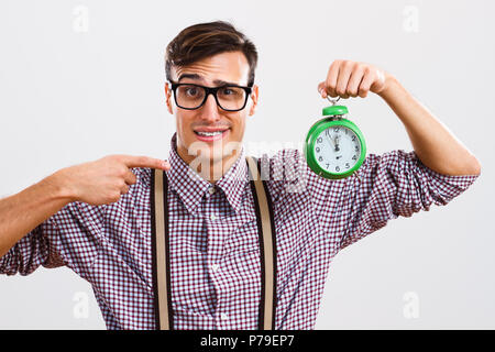 Nerdy homme pointant à l'horloge. Banque D'Images