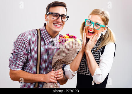 L'homme est nerdy donnant des fleurs à son nerdy dame. Banque D'Images