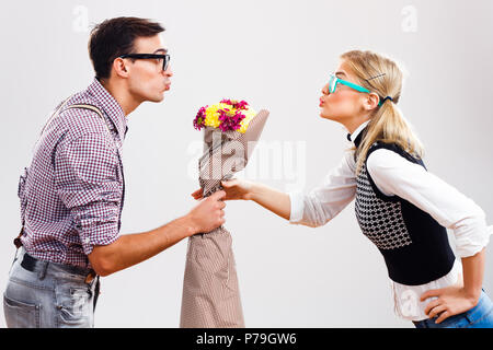 L'homme est nerdy donnant des fleurs à son nerdy dame. Banque D'Images