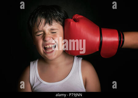 L'obtention d'un petit garçon de boxe punch de globe sur fond noir Banque D'Images