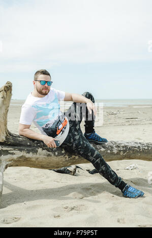 Jeune homme barbu, vêtu de vêtements pour les jeunes, voyages par la mer, d'aventures sur une chaude journée d'été. Banque D'Images