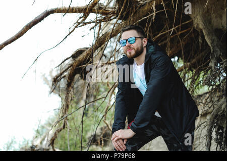 Jeune homme barbu, vêtu de vêtements pour les jeunes, voyages par la mer, d'aventures sur une chaude journée d'été. Banque D'Images