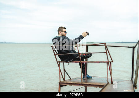 Jeune homme barbu, vêtu de vêtements pour les jeunes, voyages par la mer, d'aventures sur une chaude journée d'été. Banque D'Images