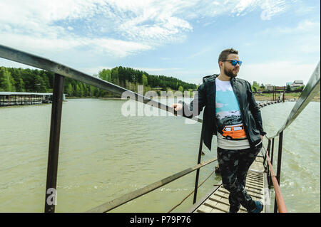 Jeune homme barbu, vêtu de vêtements pour les jeunes, voyages par la mer, d'aventures sur une chaude journée d'été. Banque D'Images