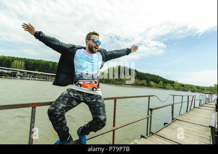 Jeune homme barbu, vêtu de vêtements pour les jeunes, voyages par la mer, d'aventures sur une chaude journée d'été. Banque D'Images