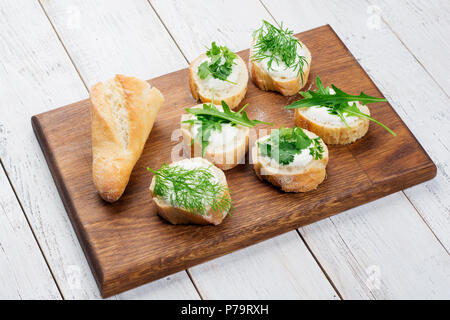 Savoureux hors-d'Italien bruschetta au fromage et d'herbes sur un fond de bois rustique Banque D'Images