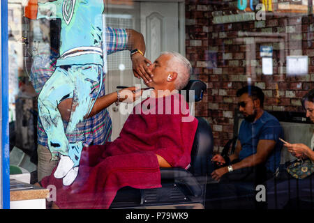 Un homme d'avoir un rasage humide dans un salon de coiffure, Brick Lane, Londres, Royaume-Uni Banque D'Images