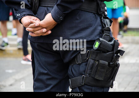 Jambe d'un policier à laquelle une arme à feu n'est constatée, la notion de sécurité Banque D'Images