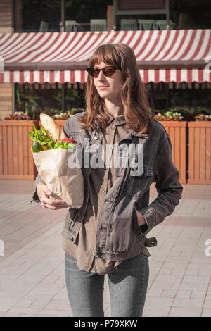 Attractive young woman in casual clothes holding style épicerie acheté de légumes locaux et d'une épicerie ou marché. Sac en Papier Recyclable de hea Banque D'Images