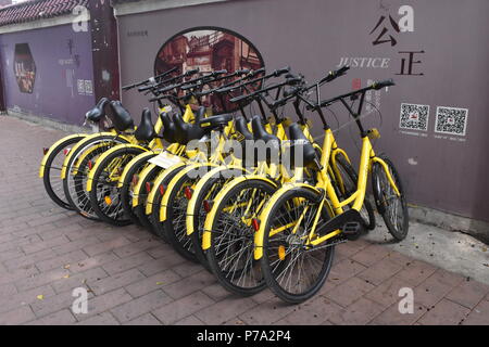 Des vélos partagés dockless Ofo garée sur un trottoir du centre-ville de Guangzhou Banque D'Images