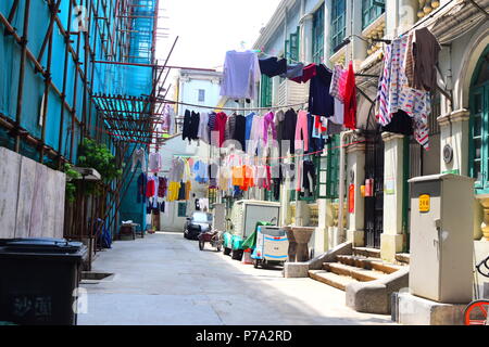 Ruelle chinois coloré rempli de vêtements pendus pour sécher dans le centre-ville de Guangzhou, Chine Banque D'Images