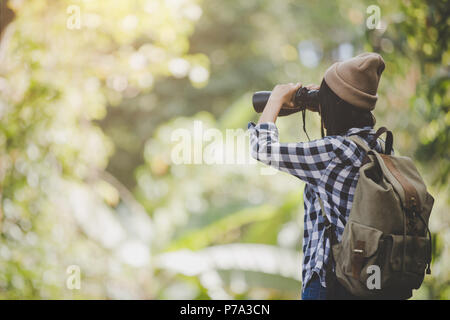 Femme avec jumelles et télescope en forêt tropicale.Travel concept, concept de randonnée. Banque D'Images