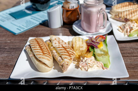 Faire fondre thon paninis avec une salade sur une assiette blanche oblongue à l'extérieur d'un café à St Annes, Lancashire, UK Banque D'Images