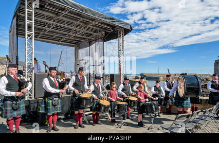 PORTSOY ABERDEENSHIRE ECOSSE FESTIVAL DE CORNEMUSES ET TAMBOURS PORTSOY BANDE PRÈS DE LA SCÈNE, SURPLOMBANT LE PORT ET À JOUER POUR UN PUBLIC Banque D'Images