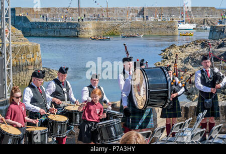 FESTIVAL DE PORTSOY ABERDEENSHIRE ECOSSE PORTSOY TUYAU ET DE TAMBOURS LE GROUPE JOUE ET DES BATEAUX DE COURSE ENTRER ET QUITTER LE PORT Banque D'Images