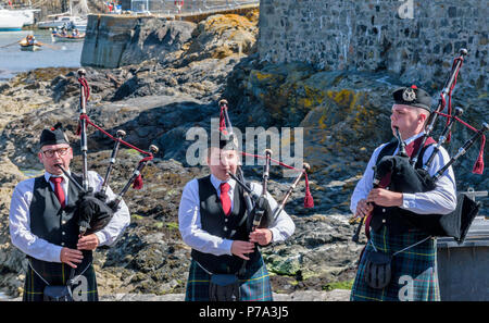 FESTIVAL DE PORTSOY ABERDEENSHIRE ECOSSE PORTSOY PIPE ET TROIS TAMBOURS PIPERS JOUANT SUR LE PORT Banque D'Images