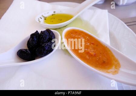 La cuisine grecque. Les petits plats de service d'huile d'olive, olives noires et purée de tomate Banque D'Images