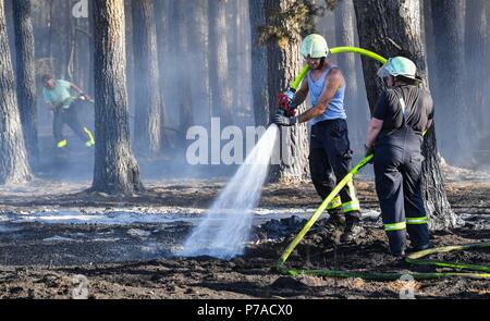 Allemagne, Limsdorf. 4 juillet, 2018. Le personnel a publié la dernière lueur et d'étincelles dans une forêt de pins. L'incendie qui a attrapé sur quelque 100 hectares de forêts et de terres sur le terrain a été mis sur le jeudi soir. Plus de 13 heures ont été nécessaires pour éteindre le feu dans le district de Limsdorf, comme le service des incendies déclarés. La police n'est pas encore en mesure de fournir une source pour le feu. Le Brandebourg est en ce moment à son plus haut risque pour les incendies de forêt. Crédit : Patrick Pleul/dpa-Zentralbild/dpa/Alamy Live News Banque D'Images