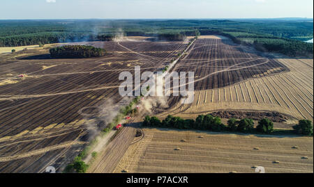 Allemagne, Limsdorf. 4 juillet, 2018. Les voitures de pompiers en voiture par le champ. L'incendie qui a attrapé sur quelque 100 hectares de forêts et de terres sur le terrain a été mis sur le jeudi soir. Plus de 13 heures ont été nécessaires pour éteindre le feu dans le district de Limsdorf, comme le service des incendies déclarés. La police n'est pas encore en mesure de fournir une source pour le feu. Le Brandebourg est en ce moment à son plus haut risque pour les incendies de forêt. Crédit : Patrick Pleul/dpa-Zentralbild/dpa/Alamy Live News Banque D'Images