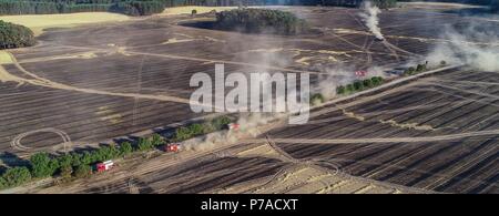 Allemagne, Limsdorf. 4 juillet, 2018. Les voitures de pompiers sur le terrain. L'incendie qui a attrapé sur quelque 100 hectares de forêts et de terres sur le terrain a été mis sur le jeudi soir. Plus de 13 heures ont été nécessaires pour éteindre le feu dans le district de Limsdorf, comme le service des incendies déclarés. La police n'est pas encore en mesure de fournir une source pour le feu. Le Brandebourg est en ce moment à son plus haut risque pour les incendies de forêt. Crédit : Patrick Pleul/dpa-Zentralbild/dpa/Alamy Live News Banque D'Images