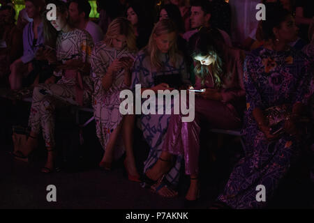 Berlin, Allemagne. 05 juillet, 2018. Des gens assis avant le début du défilé. Les collections pour le printemps/été 2019 sont présentés à la Berlin Fashion Week. Credit : Gregor Fischer/dpa/Alamy Live News Banque D'Images