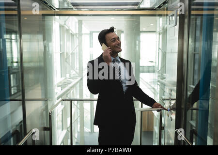 Businessman talking on the phone dans l'élévateur Banque D'Images