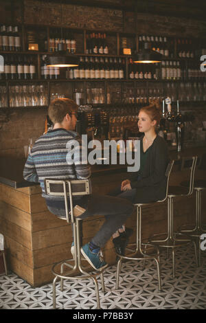 Couple assis à l'comptoir bar Banque D'Images