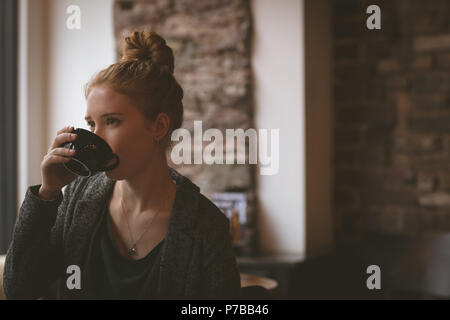 Woman having coffee at cafe Banque D'Images