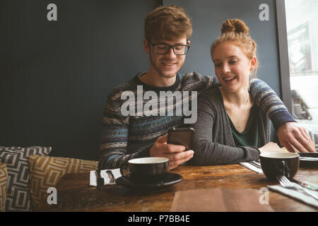 Jeune couple using mobile phone Banque D'Images