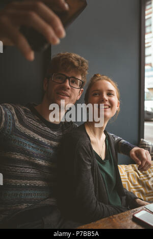 Un couple dans le café selfies Banque D'Images