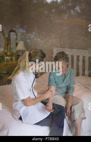 Physiotherapist examining a senior woman with stethoscope Banque D'Images