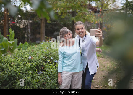 Physiothérapeute et senior woman taking a selfies Banque D'Images