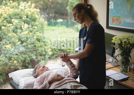 Physiothérapeute en donnant un coup de main pour massage senior woman Banque D'Images