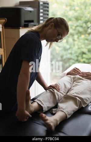 Physiothérapeute donnant un massage des jambes pour senior woman Banque D'Images
