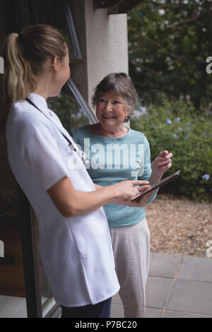 Physiothérapeute et senior woman using a tablet Banque D'Images