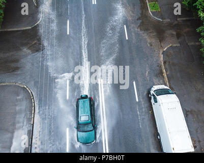 Speedy black car la conduite sur la rue inondée après de fortes pluies. Vue aérienne Banque D'Images