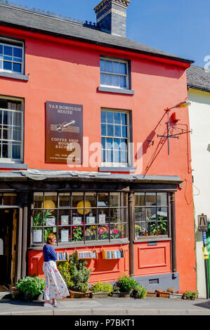 Femme debout à l'extérieur du Yarborough chambre deuxième main book shop et un café à Bishops Castle, Shropshire, Angleterre, Royaume-Uni Banque D'Images