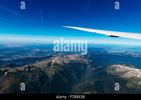 Vue aérienne de paysage à travers la fenêtre de l'avion contre le ciel bleu Banque D'Images