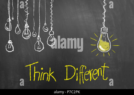 Think different concept avec texte et dessin d'ampoules sur tableau ou le tableau noir comme l'innovation la créativité nouvelle vision concept Banque D'Images