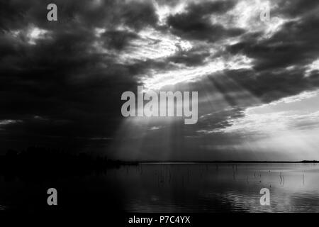 Parfaitement symétrique et vue spectaculaire d'un lac, avec des nuages, le ciel et les rayons du soleil reflétant sur l'eau Banque D'Images