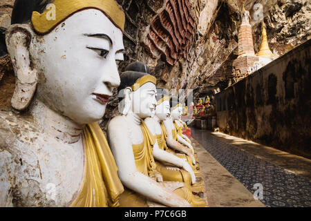 Statues de Bouddha dans une rangée, sous des murs en calcaire de Kawgun grotte près de Hpa-an, au Myanmar, en Asie Banque D'Images