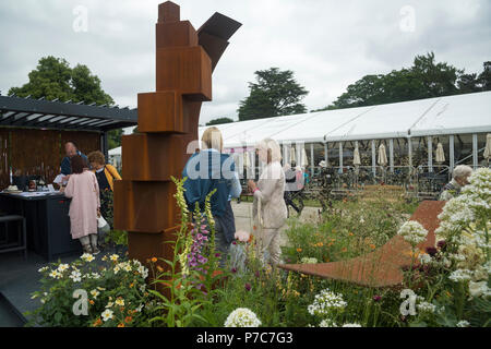 Personnes debout, parler par l'affichage d'un grand jardin de sculptures en métal d'origine sur le commerce stand - RHS Flower Show de Chatsworth, Derbyshire, Angleterre, RU Banque D'Images