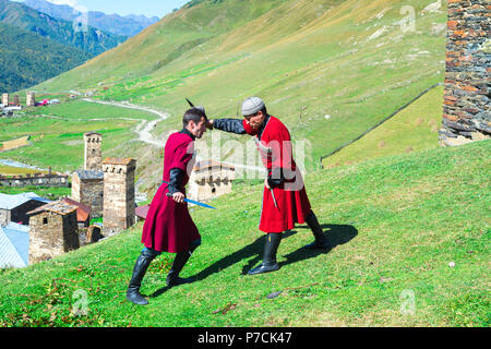 Dagger fighting show par deux hommes géorgien d'un groupe folklorique, Ushguli, région de Svaneti, Géorgie Banque D'Images