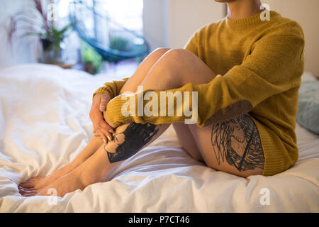 Woman relaxing on lit dans la chambre à la maison Banque D'Images