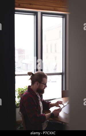 Male executive using digital tablet at desk Banque D'Images