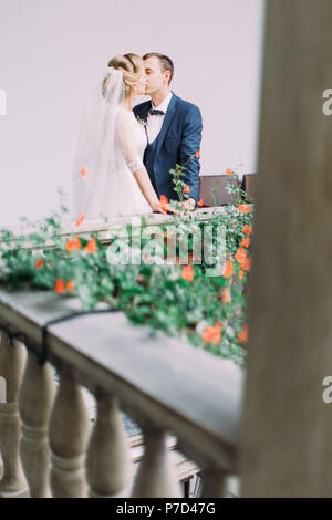 Beau balcon avec des fleurs et des baisers couple sur elle. Banque D'Images
