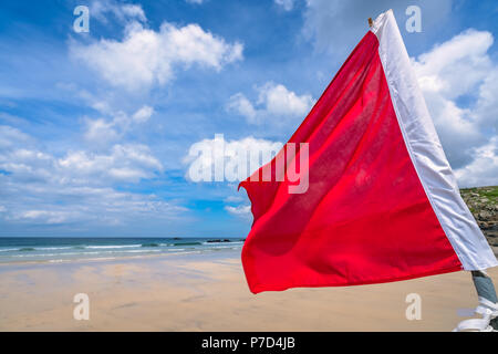 Drapeau rouge signalant que le surf et la natation sont interdits en raison d'un vent fort, les vagues et les courants sur une plage à St Ives, Cornwall, England, UK Banque D'Images