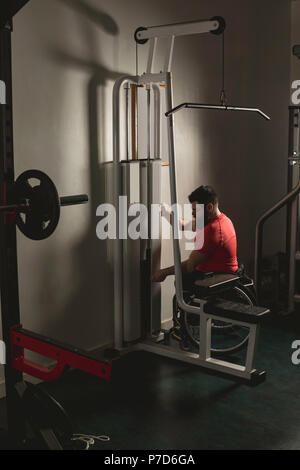 Homme handicapé en fauteuil roulant sur l'augmentation de poids d'exercice déroulant Banque D'Images